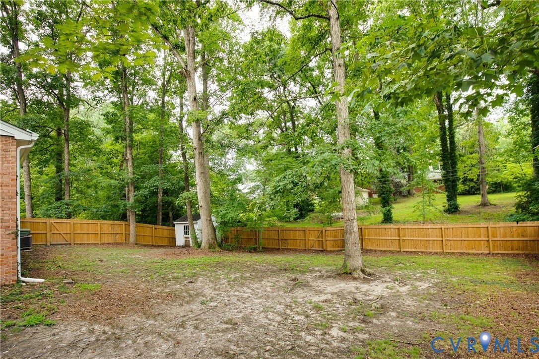 200 Stanmore Road, North Chesterfield, VA 23236 Expansive backyard featuring a wood privacy fence, mature trees, and an exterior storage shed
