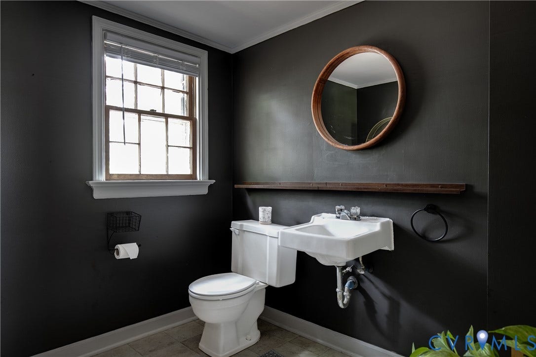 200 Stanmore Road, North Chesterfield, VA 23236 bathroom featuring a white toilet, wall-mounted sink, and a wood-framed round mirror