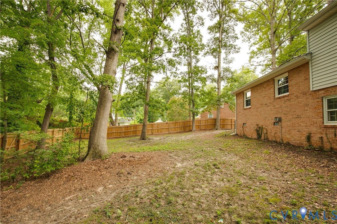 200 Stanmore Road, North Chesterfield, VA 23236 Rear exterior featuring brick and siding, multiple windows, and a wood privacy fence