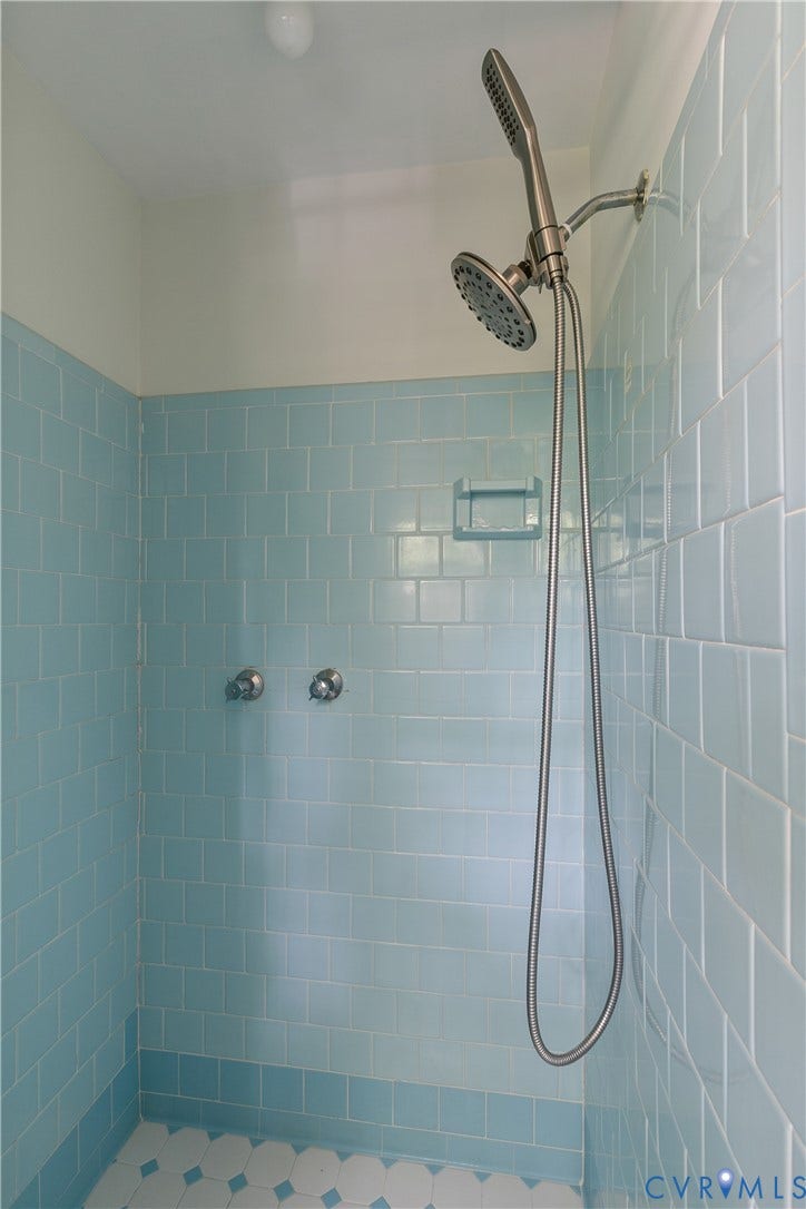 200 Stanmore Road, North Chesterfield, VA 23236 Shower stall featuring blue subway tile, an integrated soap dish, and a dual-head shower system with a handheld sprayer