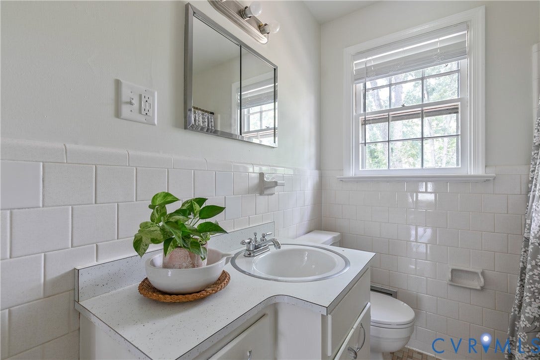 200 Stanmore Road, North Chesterfield, VA 23236 Bathroom featuring a white tile wainscoting, a single-pane window with blinds, a built-in vanity with an integrated sink, and a mirrored medicine cabinet