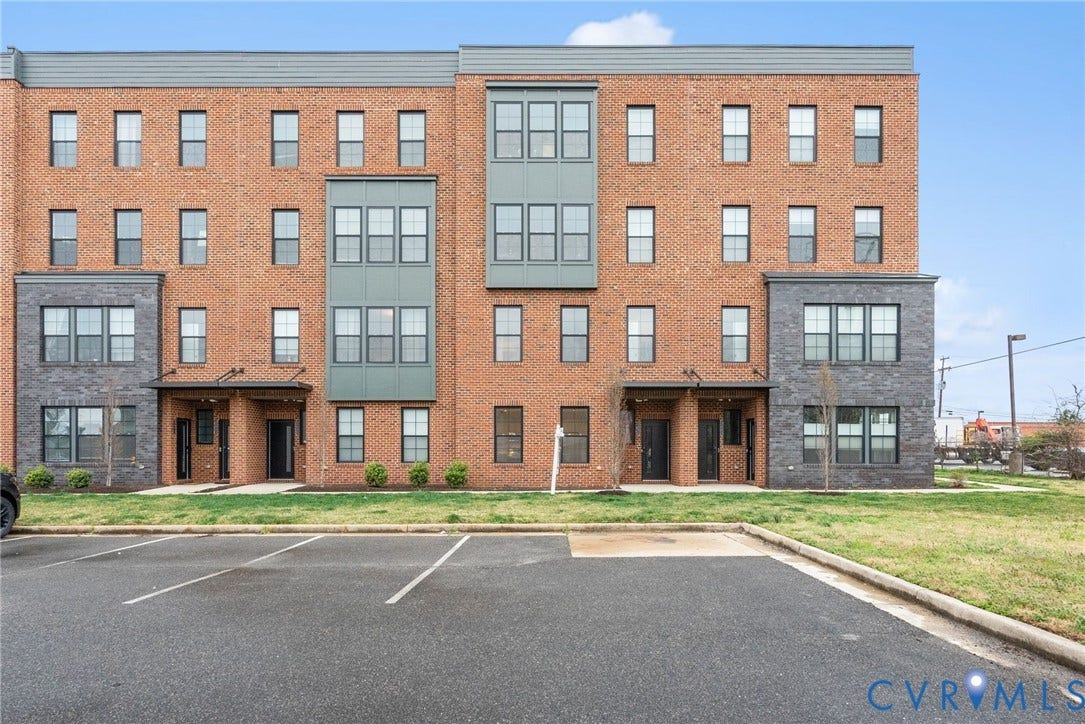 2439 Ownby Lane, #B 13, Richmond, VA 23220 Brick exterior with contrasting dark grey siding accents, multiple windows, covered entryways, and adjacent paved parking