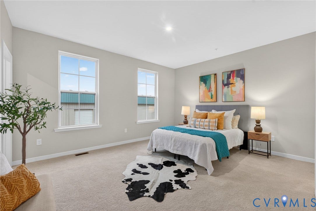 2439 Ownby Lane, #B 13, Richmond, VA 23220 Spacious primary bedroom showcasing abundant natural light from dual windows, neutral wall finishes, recessed ceiling lighting, and light wood-finish flooring throughout