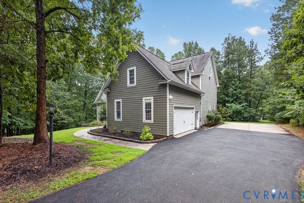 8825 First Branch Lane, Chesterfield, VA 23838 Two-story exterior with dormer windows, attached garage, paved driveway, and established landscaping