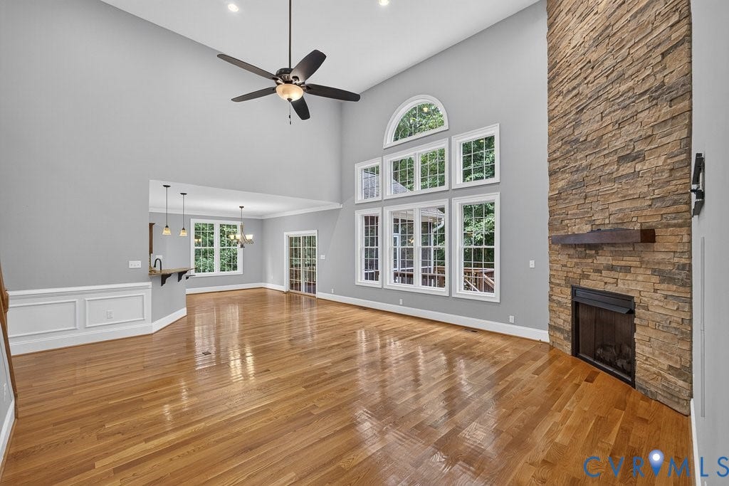 8825 First Branch Lane, Chesterfield, VA 23838 Vaulted ceilings with recessed lighting, hardwood flooring, stacked stone fireplace with wood mantel, multiple windows with transom, and panel molding