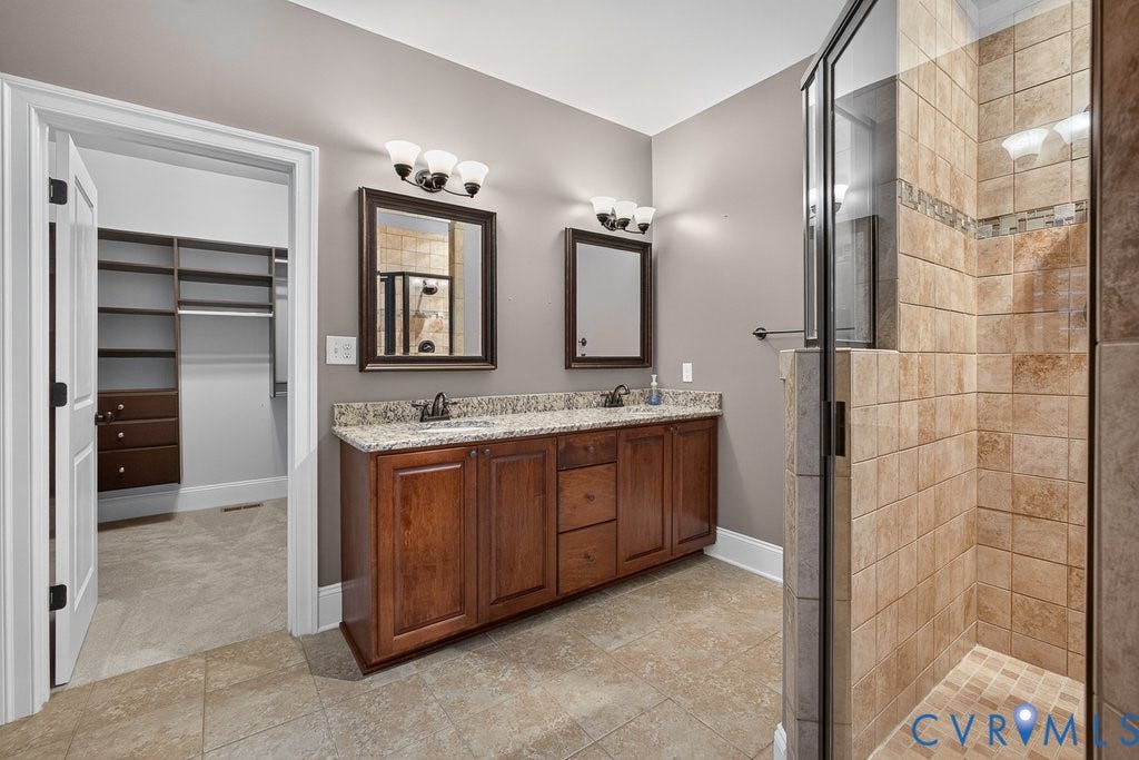 8825 First Branch Lane, Chesterfield, VA 23838 Spa-inspired primary bathroom featuring a dual-sink vanity with wood cabinetry, granite countertop, and polished nickel fixtures
