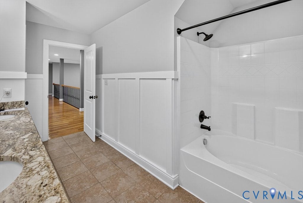 8825 First Branch Lane, Chesterfield, VA 23838 Dual vanity with stone countertop, tile flooring, board and batten wall detailing, and a tub/shower combination with matte black fixtures