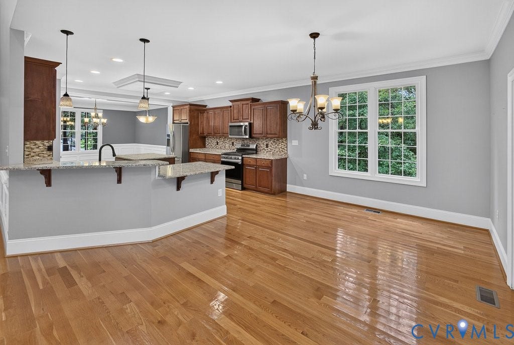 8825 First Branch Lane, Chesterfield, VA 23838 Hardwood flooring throughout, kitchen with wood cabinetry, stainless steel appliances, and a tiled backsplash
