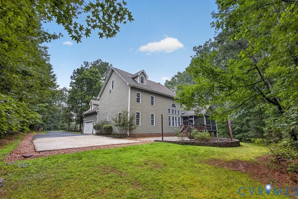 8825 First Branch Lane, Chesterfield, VA 23838 Two-story siding exterior with multiple dormer windows, attached garage, screened porch, and a stone-edged planting bed