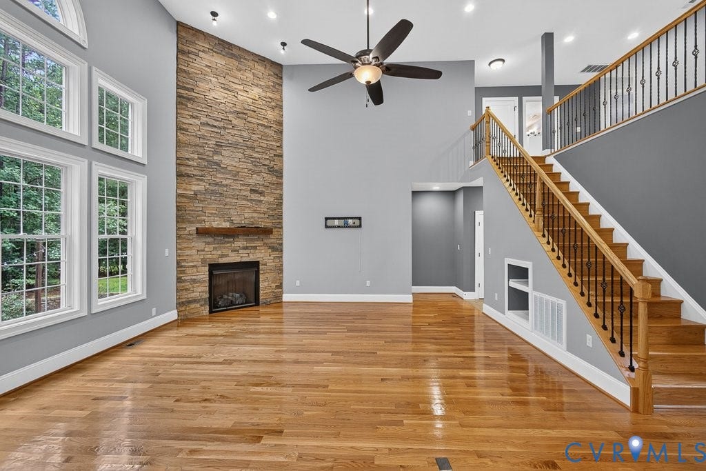 8825 First Branch Lane, Chesterfield, VA 23838 Hardwood flooring throughout, a stacked stone fireplace with a wood-finish mantel, and a two-story ceiling