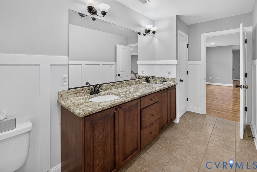 8825 First Branch Lane, Chesterfield, VA 23838 Dual vanity with a stone countertop, integral sinks, and dark wood-finish cabinetry