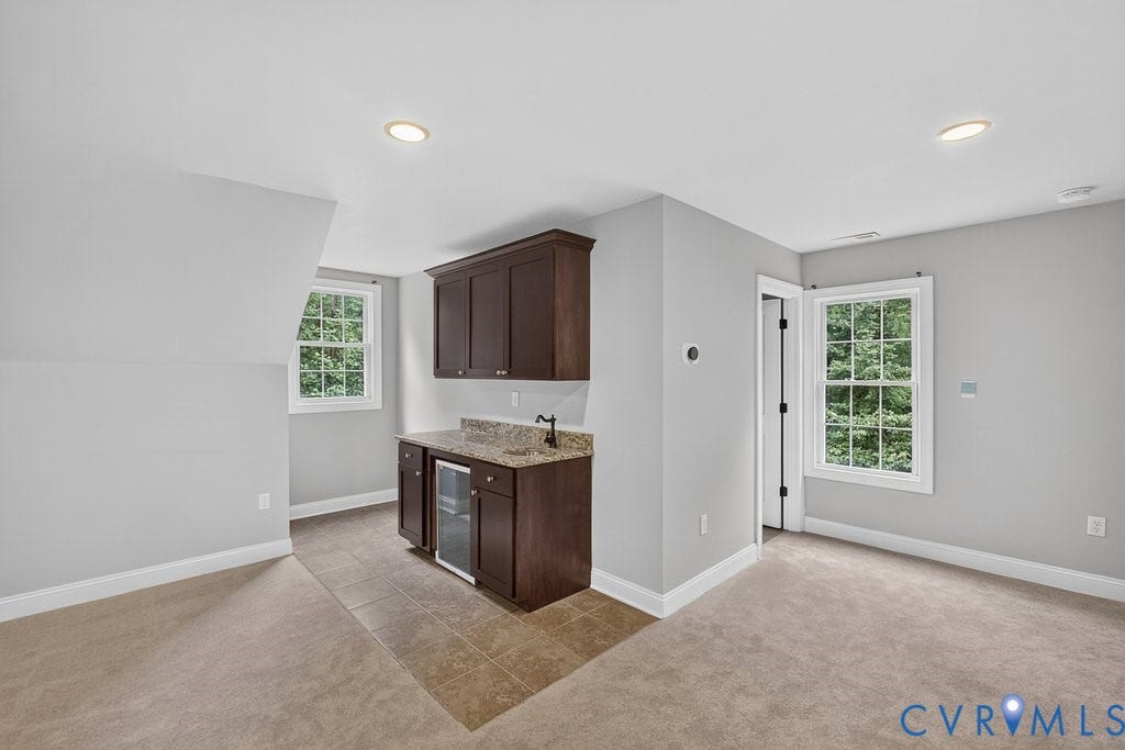 8825 First Branch Lane, Chesterfield, VA 23838 Built-in wet bar with dark wood cabinetry, granite-style countertop, and integrated beverage cooler
