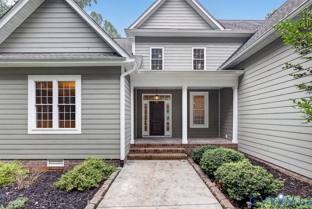 8825 First Branch Lane, Chesterfield, VA 23838 Exterior featuring gray horizontal siding, an inviting covered entry with white columns, brick steps, and a concrete pathway