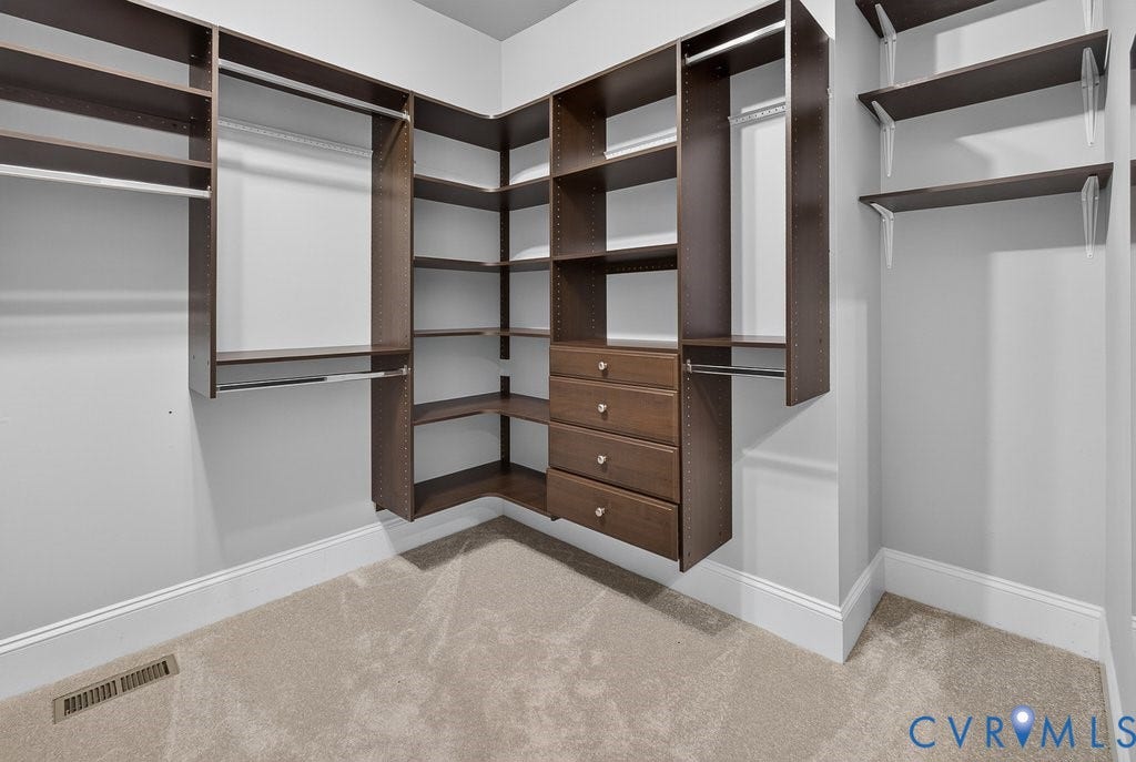 8825 First Branch Lane, Chesterfield, VA 23838 Custom closet system featuring dark wood-finish cabinetry, built-in shelving, multiple hanging rods, and integrated drawers