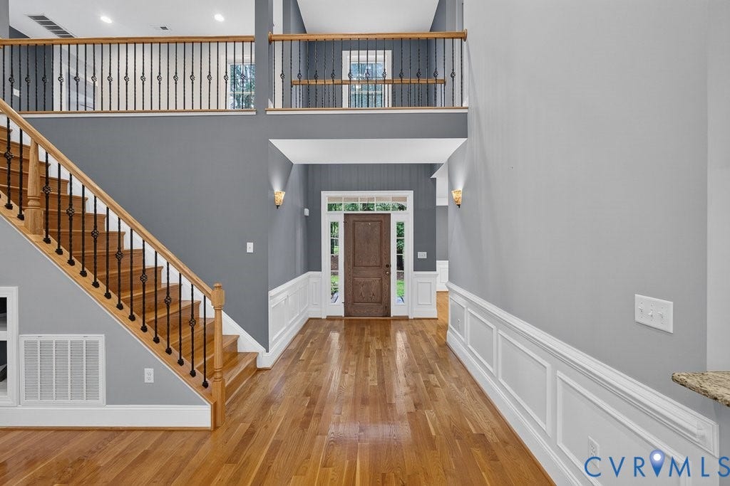 8825 First Branch Lane, Chesterfield, VA 23838 Hardwood flooring throughout, two-story foyer, elegant wainscoting, solid wood entry door, and decorative wrought iron balusters