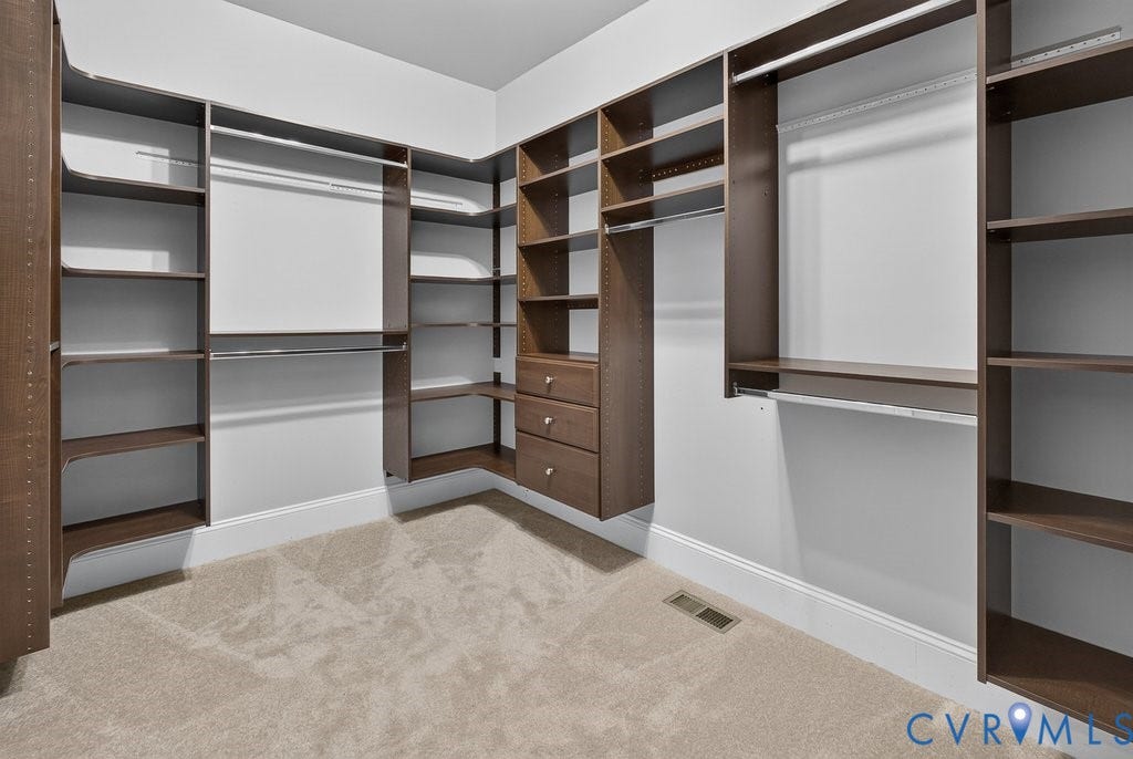 8825 First Branch Lane, Chesterfield, VA 23838 Custom closet system featuring wood-finish shelving, multiple hanging rods, and built-in drawers