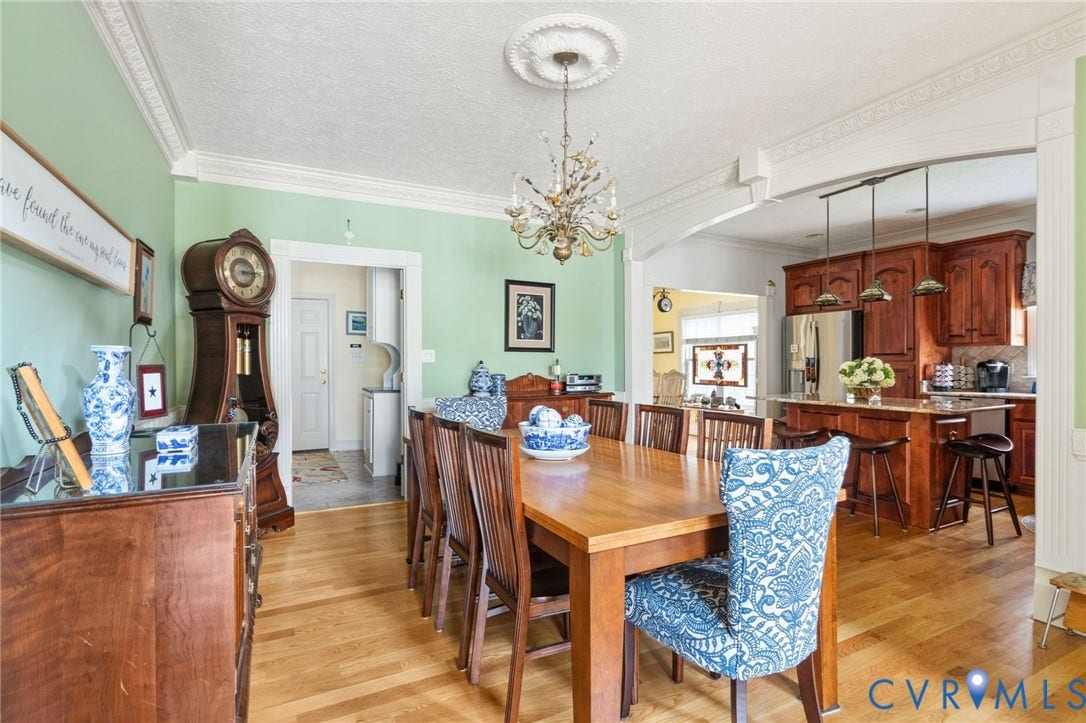 Dining area featuring light wood-finish flooring, an ornate ceiling medallion, and decorative crown molding