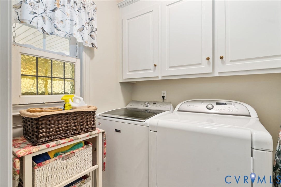 Utility area featuring white shaker-style cabinetry, gold-toned hardware, and a window with textured glass