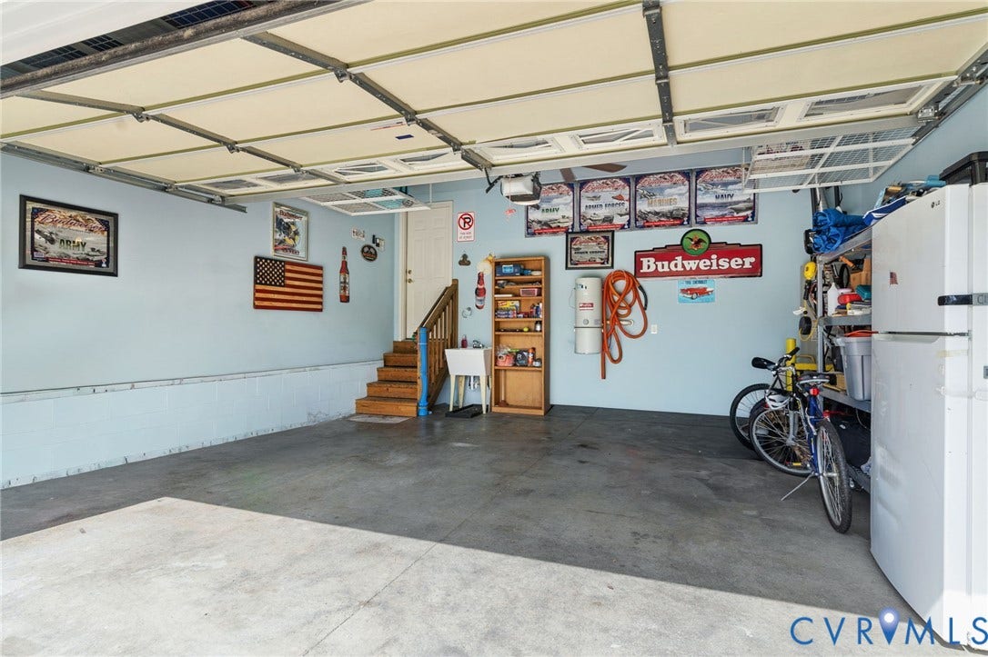 Spacious garage with concrete flooring, light blue walls, and a multi-panel overhead door