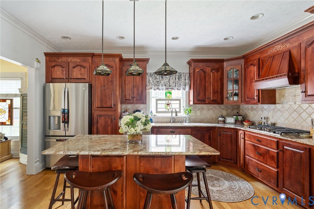 Kitchen featuring wood-finish cabinetry, stainless steel appliances, granite countertops, and a tiled backsplash