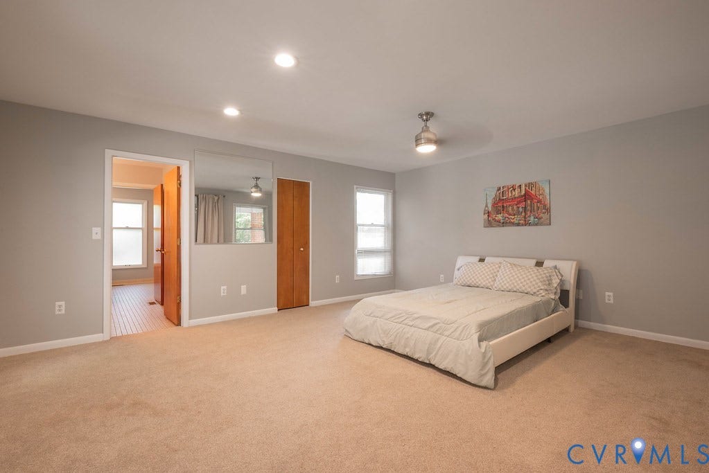 Spacious room with recessed lighting, ceiling fan, and two windows