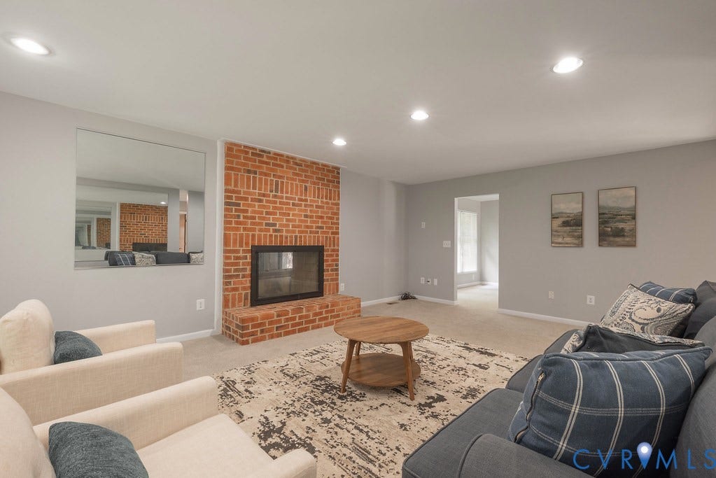 Brick fireplace with a glass front, recessed lighting, and carpeted flooring
