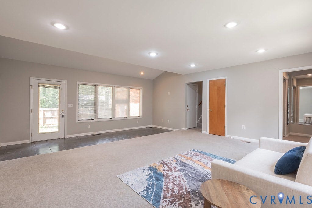 Recessed lighting illuminates the open living area with an angled ceiling
