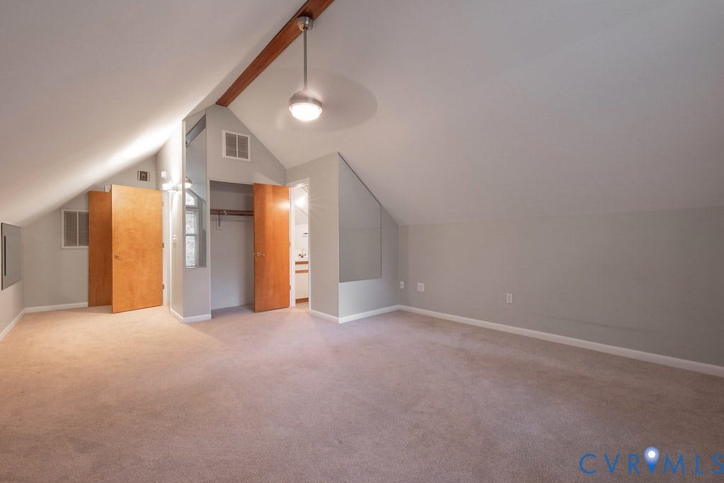 Vaulted ceiling with exposed wood beam, recessed lighting, and wall-to-wall carpeting