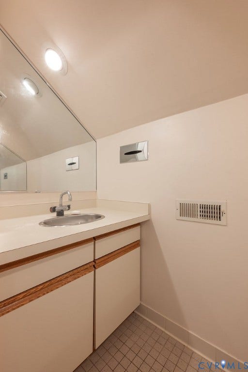 Recessed lighting, large vanity mirror, single basin sink with chrome faucet, built-in vanity cabinetry, and tiled flooring