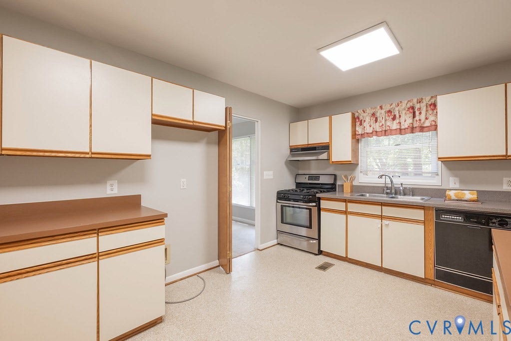 Kitchen featuring built-in cabinetry, stainless steel range with hood, dual-basin sink, and recessed ceiling lighting