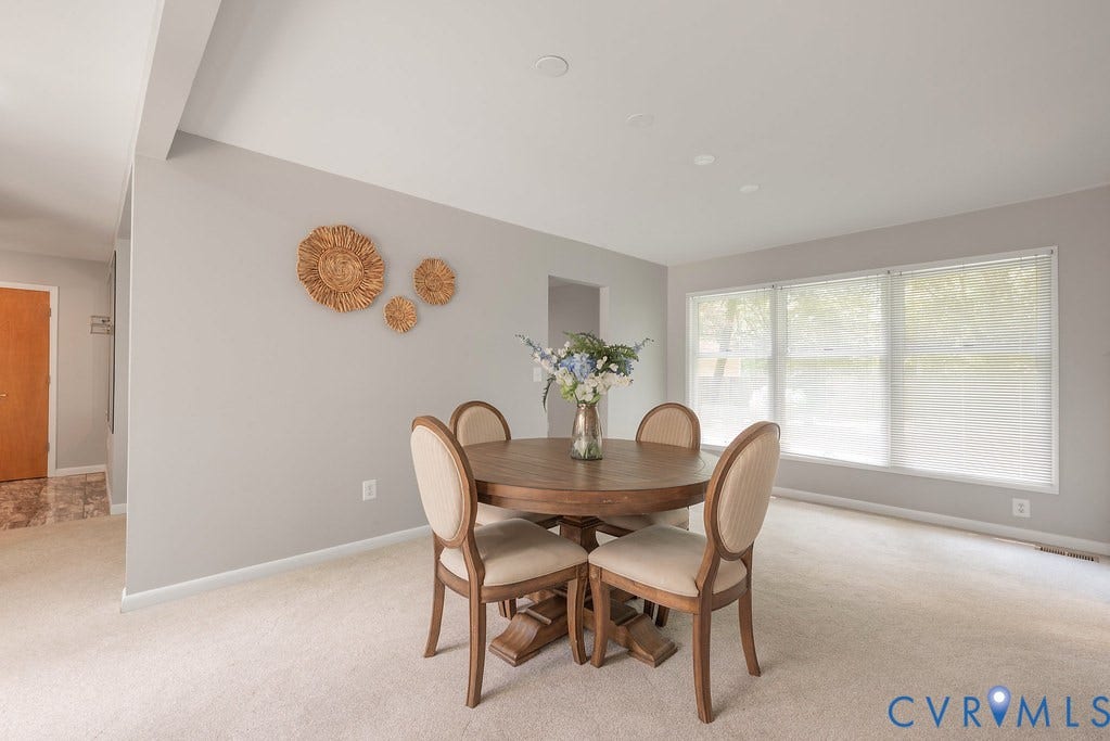 Carpeted flooring, recessed lighting, and a large window with blinds