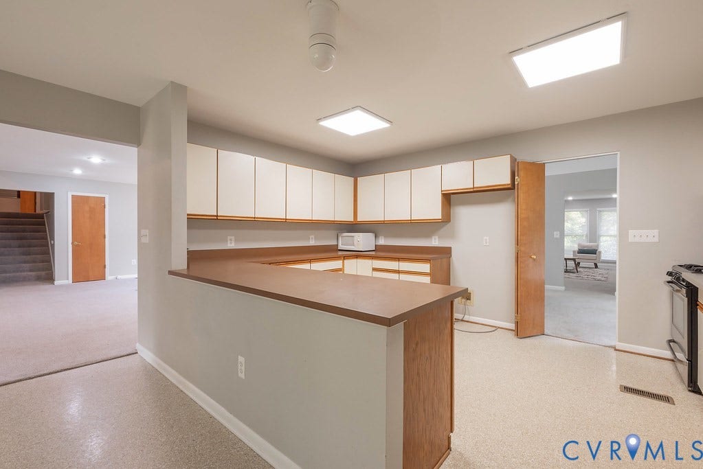 Kitchen featuring a peninsula counter with wood-finish cabinetry, speckled flooring, and recessed lighting
