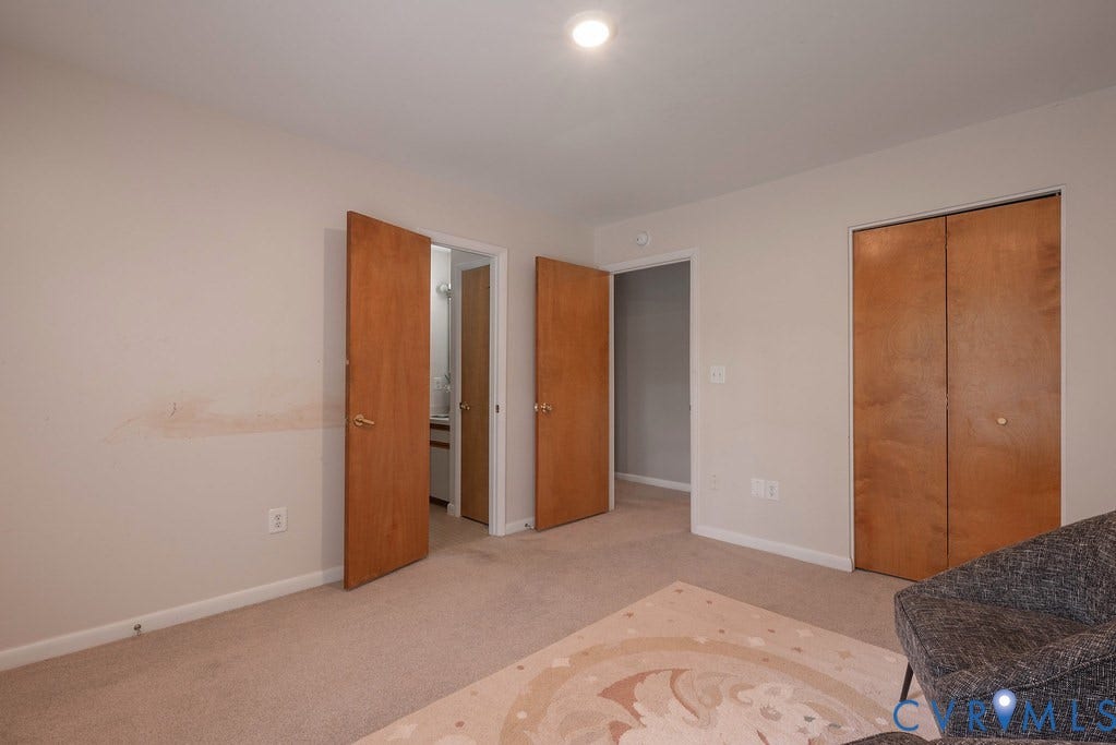 Neutral-toned wall finish, recessed ceiling lighting, and light-colored carpeting