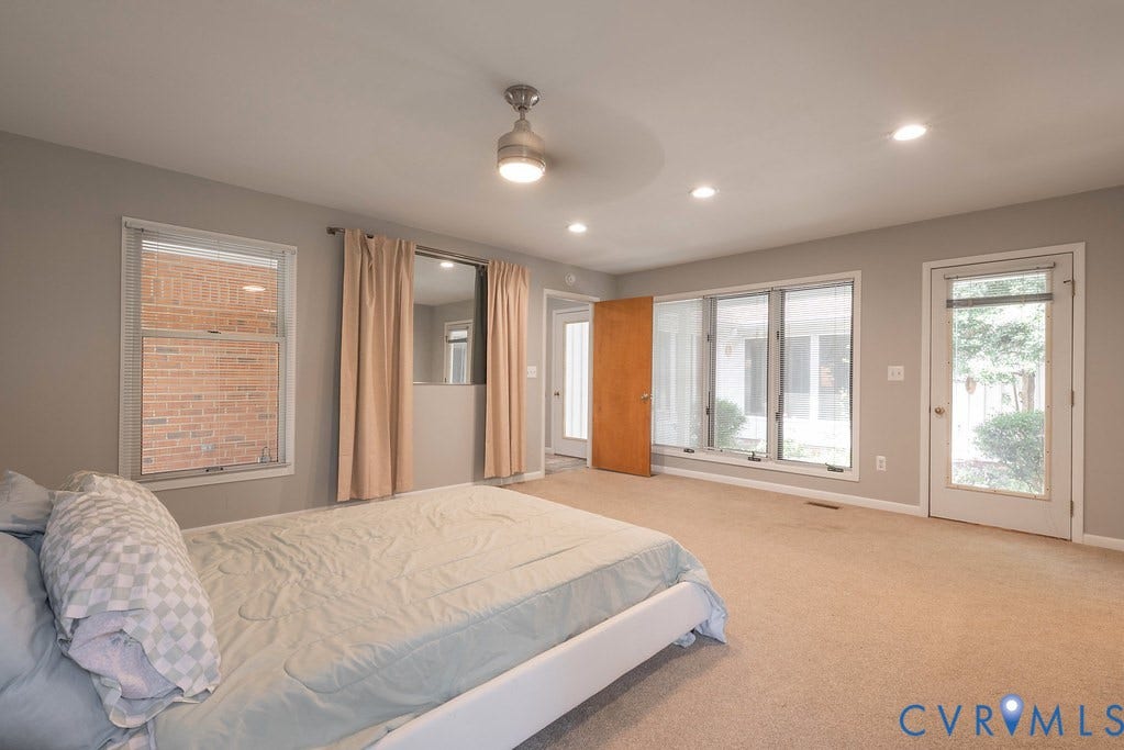 Recessed lighting, ceiling fan light fixture, carpeted flooring, multiple windows, and a glass-paneled door