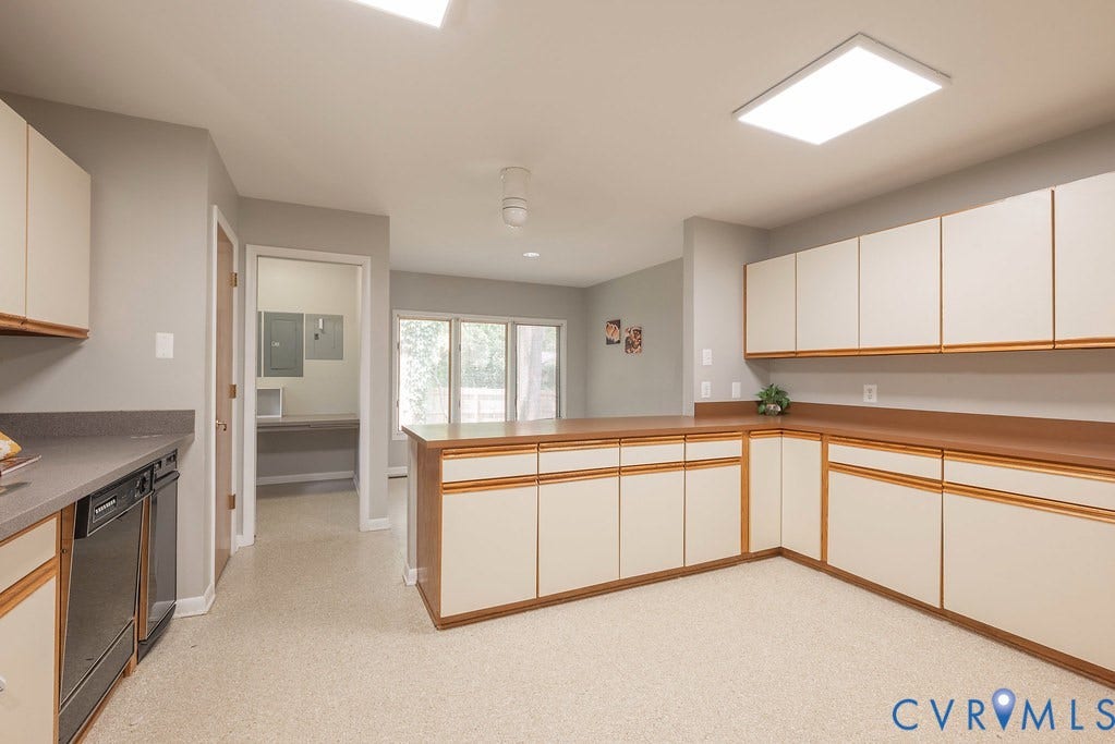 Extensive built-in cabinetry with wood-finish countertops, integrated dishwasher, and recessed ceiling lighting