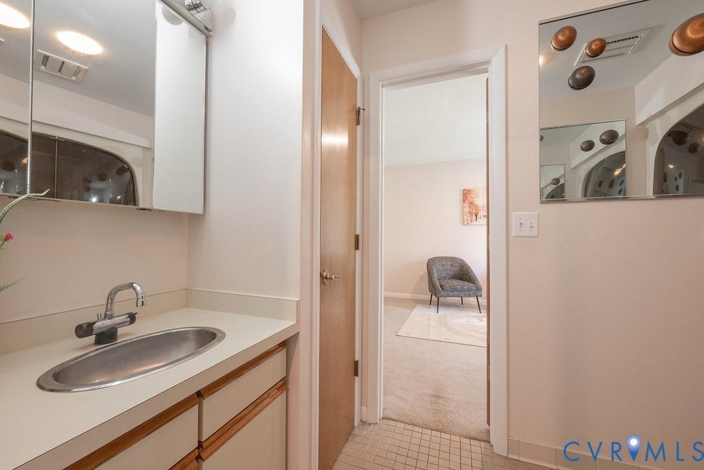Bathroom vanity with an integrated sink, polished chrome faucet, and wood-finish cabinetry
