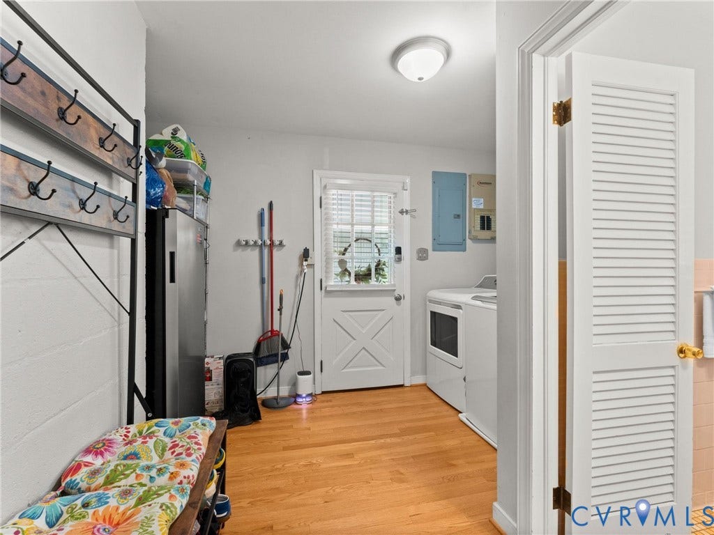 Laundry area with wood-finish flooring, white walls, and a recessed light fixture