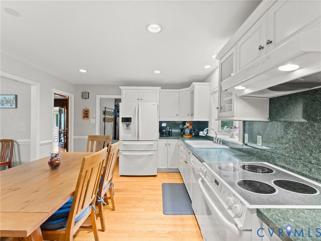 Kitchen featuring white cabinetry, integrated appliances, recessed lighting, green flecked countertops, and wood-finish flooring