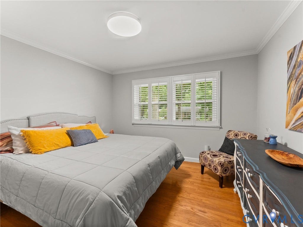 Bedroom featuring wood-finish flooring and crown molding