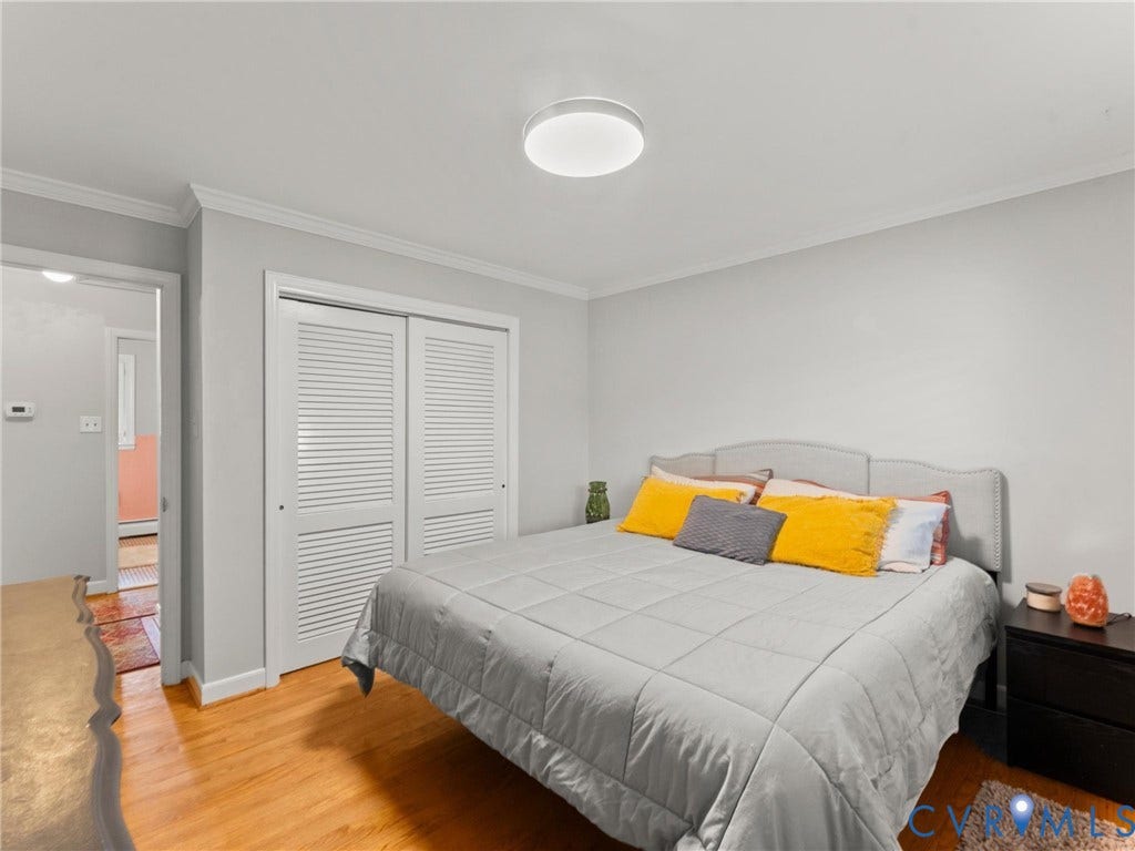 Spacious bedroom featuring a wood-finish floor, recessed ceiling lighting, and a neutral color palette