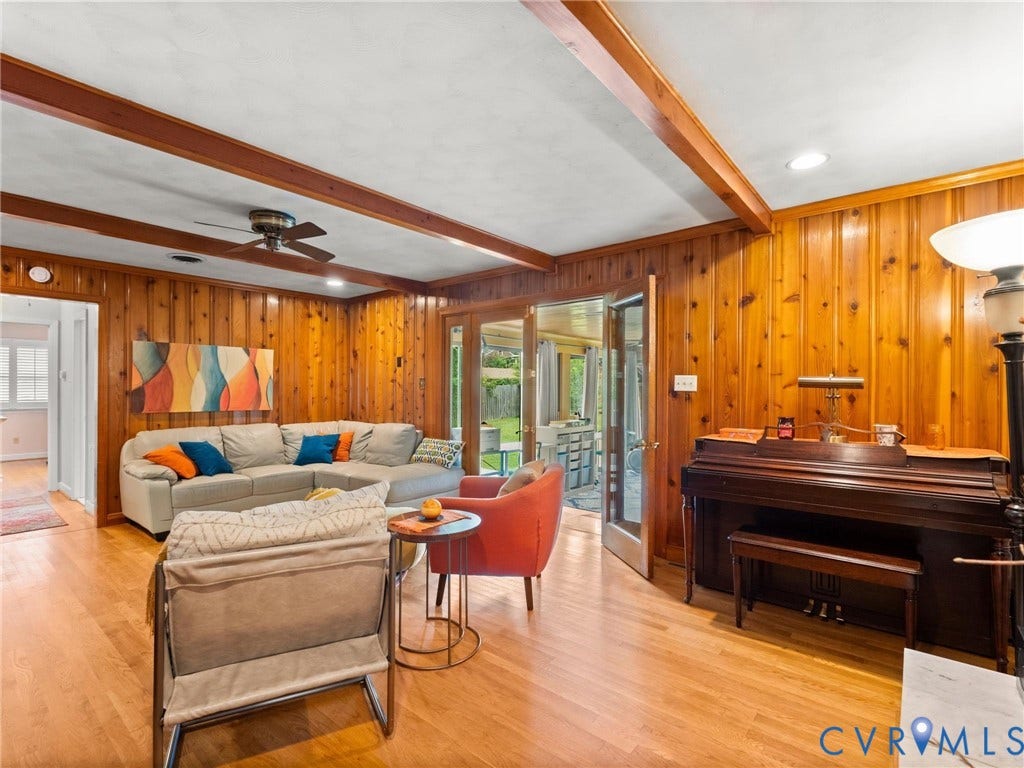Living area featuring extensive wood paneling and wood-finish flooring