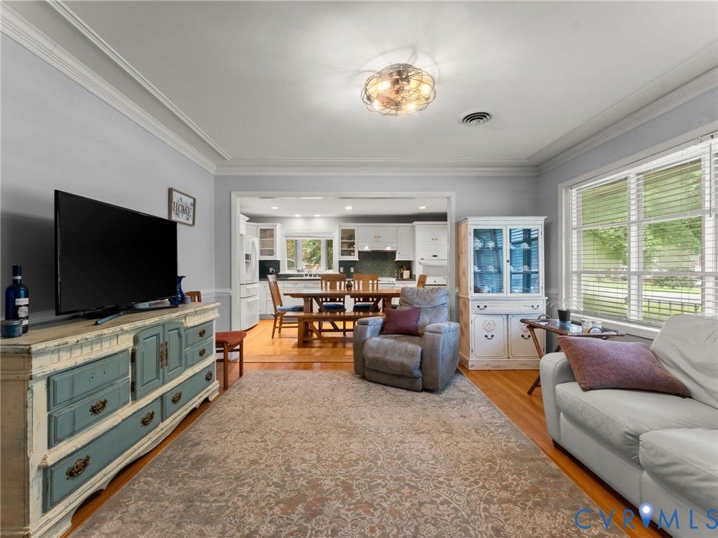 Living area featuring hardwood flooring, crown molding, and recessed lighting