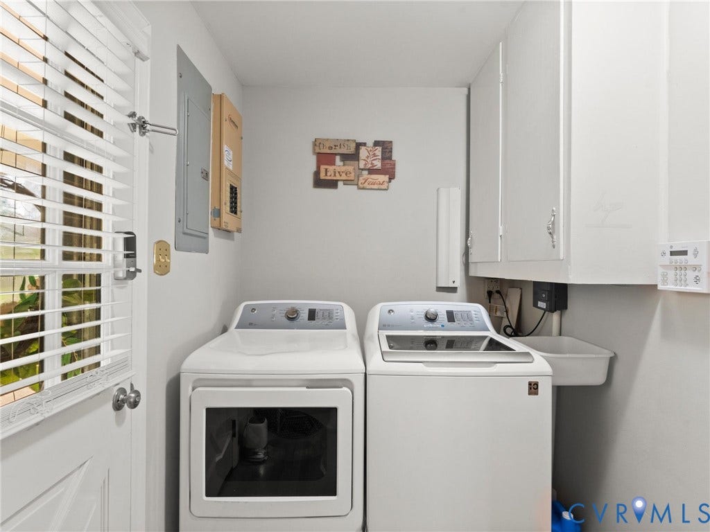 Dedicated utility space featuring overhead cabinetry and a utility sink