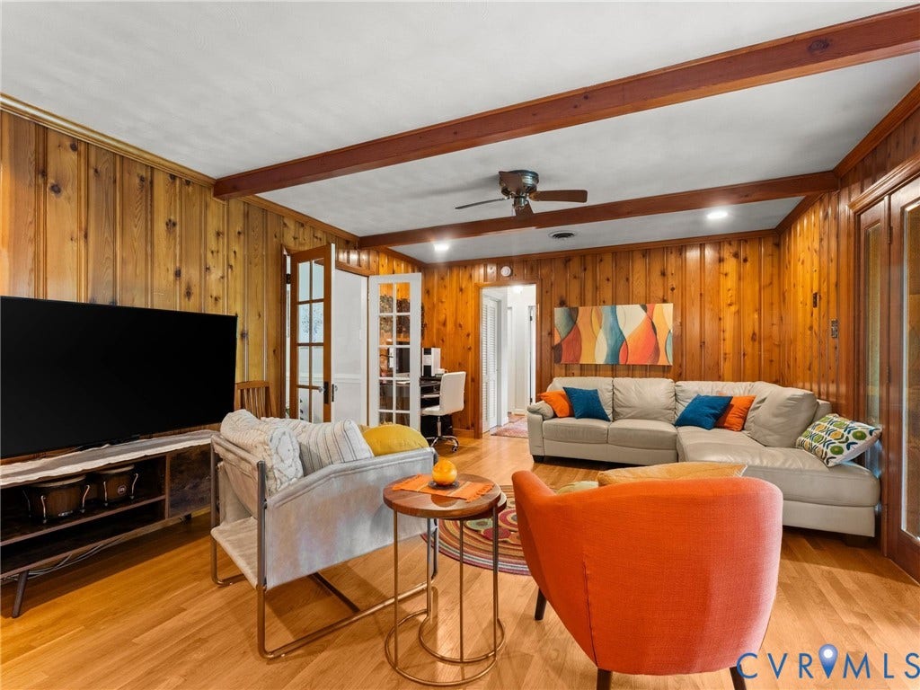 Living area featuring wood-paneled walls and wood-finish flooring