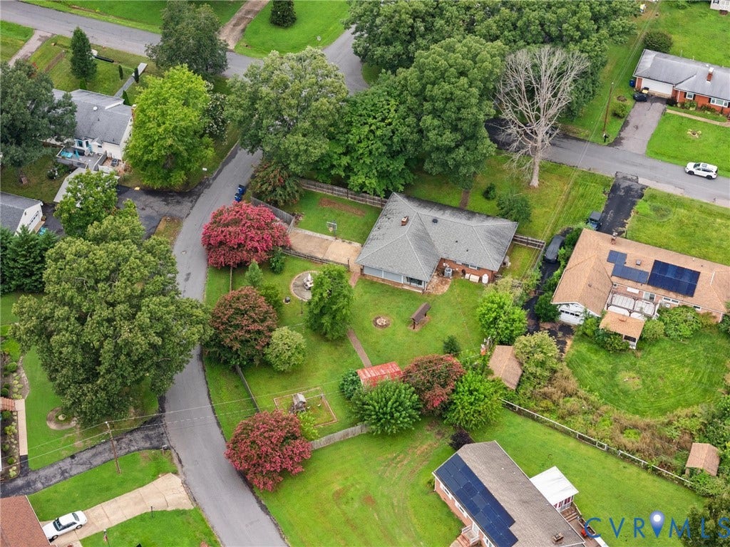 Aerial perspective showcasing a residential property with a gray shingle roof and brick siding