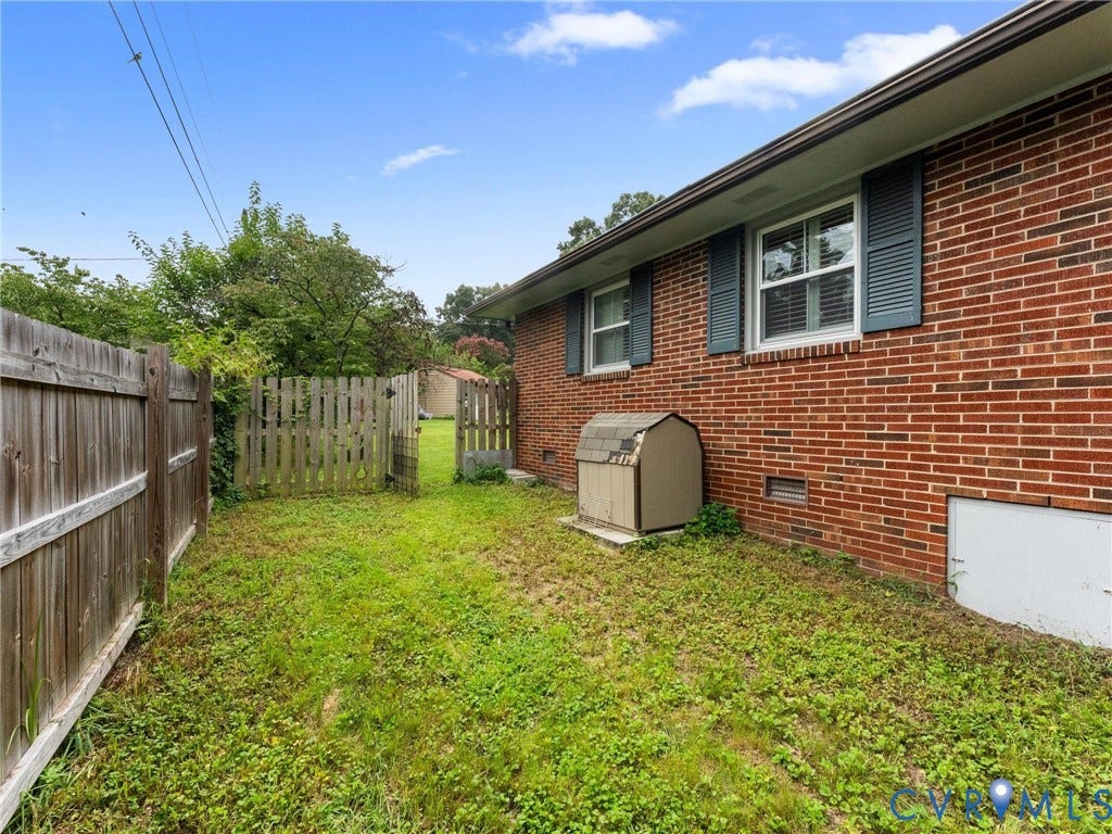 Brick exterior with multiple windows featuring louvered shutters
