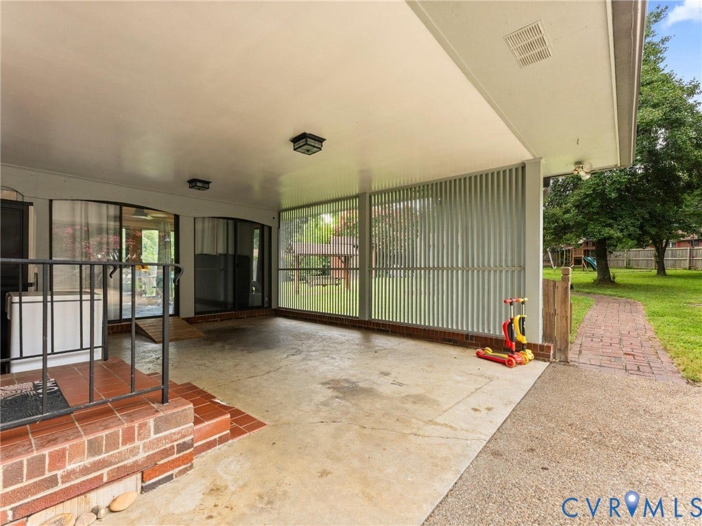 Covered patio with a concrete surface and brick surround