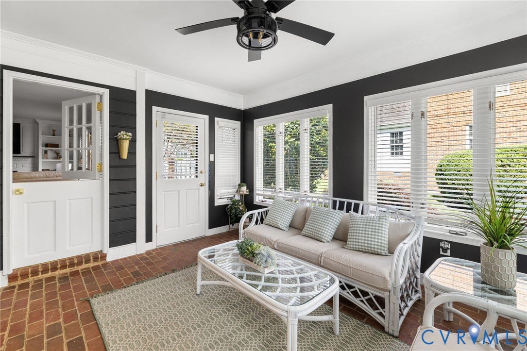 Brick flooring, multiple transom windows, white trim, black ceiling fan, and a Dutch door