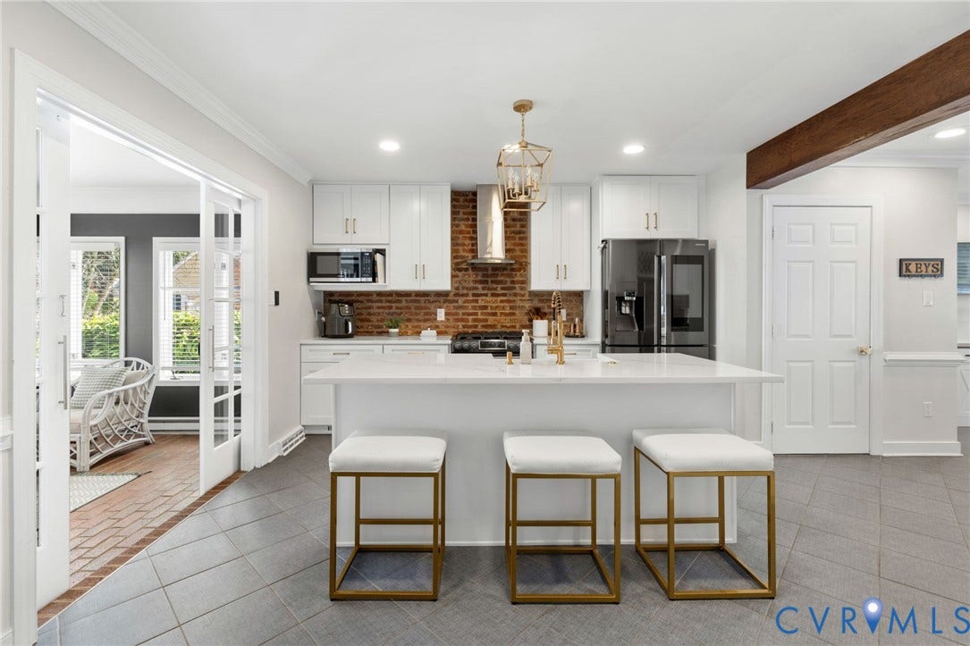 Modern kitchen featuring white cabinetry, a large center island, and integrated stainless steel appliances