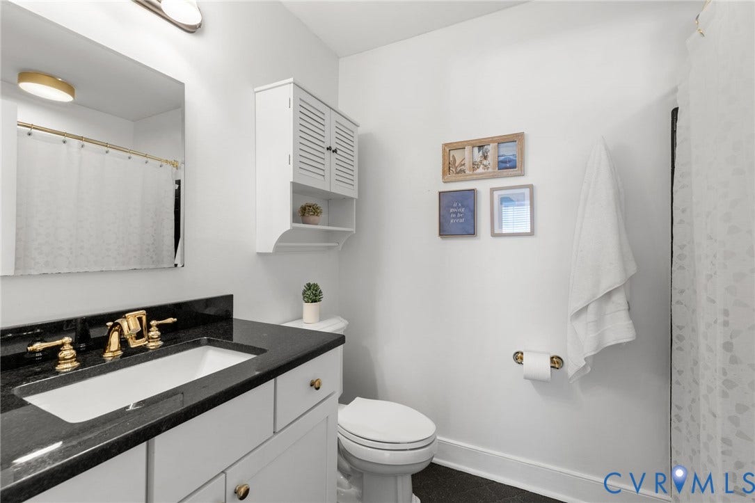 Integrated vanity with a dark stone countertop and a white undermount sink